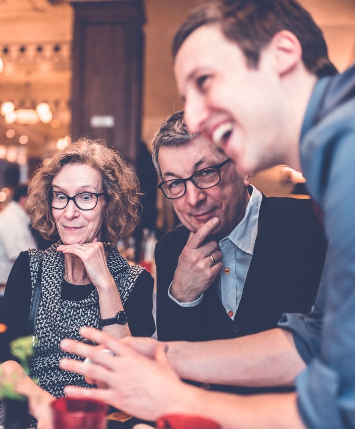 A charming magician is laughing with the guests.